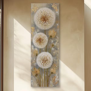 May include: Vertical canvas art featuring three large, white dandelion seed heads with brown centers. The background is a muted gray with gold accents. The artwork evokes a sense of nature and tranquility, suitable for home decor.