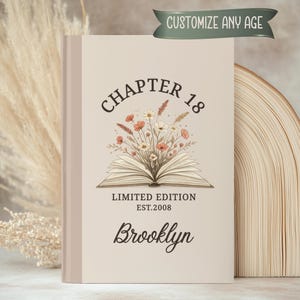 May include: A beige book with the text "CHAPTER 18" and "LIMITED EDITION EST.2008". The book features an open book illustration with flowers and the name "Brooklyn". A banner at the top reads "CUSTOMIZE ANY AGE".