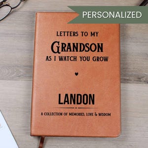 Può includere: Un diario in pelle marrone personalizzato con il testo "Letters to My Grandson" e il nome "Landon". Il diario include la frase "A Collection of Memories, Love & Wisdom".