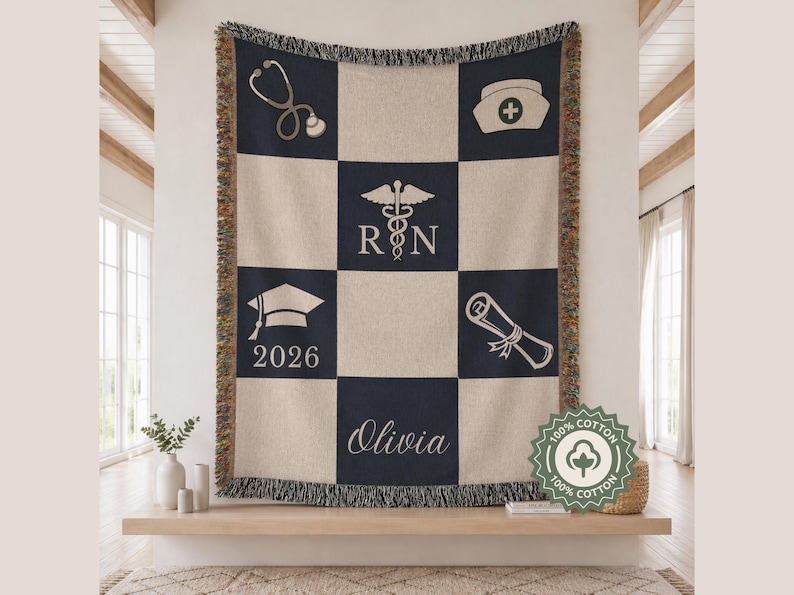 May include: A beige and navy blue woven throw blanket with a checkerboard pattern. The design includes medical symbols, a graduation cap with "2026", the name "Olivia", and the text "RN". The blanket is made of 100% cotton.
