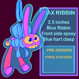May include: A cartoon-style bunny charm with a blue bow, pink body, and yellow eyes. The charm is 2.5 inches and has the text "JAX RIBBIN". The charm has a blue heart clasp and is front side epoxy.