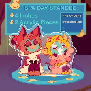 May include: A colorful acrylic standee featuring two cartoon characters in spa attire. The standee is 4 inches tall and includes two acrylic pieces. The text "SPA DAY STANDEE" is displayed at the top, with "PRE-ORDERS" and "!FREE STICKER!" also visible.
