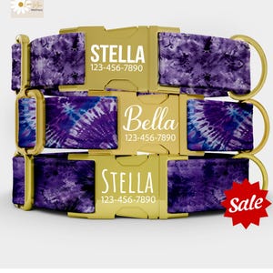 May include: Three personalized dog collars with gold-colored buckles and hardware. The collars feature a purple tie-dye pattern. Each collar displays a name and phone number in white text. A red "Sale" sticker is visible.