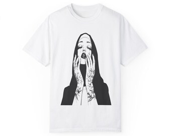 May include: White t-shirt with a black and white illustration of a woman wearing a nun's habit with her hands clasped in prayer.