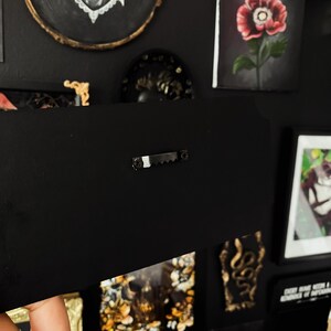 May include: A black framed canvas with a hanging hook on the back. The canvas is blank and ready for painting.