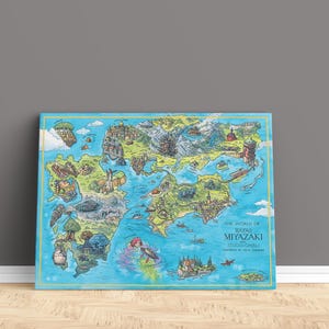 May include: A framed, illustrated map of a fantasy world, leaning against a grey wall. The map is filled with colorful landscapes and characters. Text on the map reads "The World of Hayao Miyazaki Studios Ghibli".