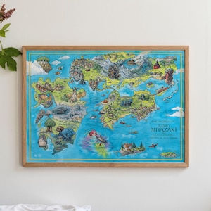 May include: A framed map illustration titled "The World of Hayao Miyazaki" depicting a colourful, whimsical fantasy world. The map has a light blue background with a yellow border, and is encased in a wooden frame. The map is in a wooden frame.