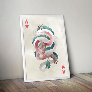 May include: A white and green dragon with pink accents is curled up in a circle. The dragon is on a white card with a red heart and the letter A in the corner. The card is framed in white.