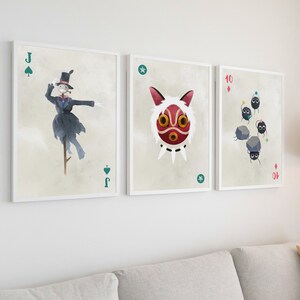May include: Three framed prints of playing cards featuring characters from the animated film Spirited Away. The first card is the Jack of Spades and features the No Face character. The second card is the Ace of Stars and features the character of the spirit mask. The third card is the 10 of Diamonds and features the soot sprites.
