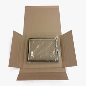 May include: A black picture frame with a clear plastic wrap around it. The frame is inside a brown cardboard box.