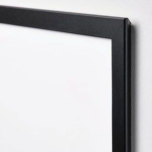 May include: A black picture frame with a white mat. The frame is made of wood and has a simple, modern design.