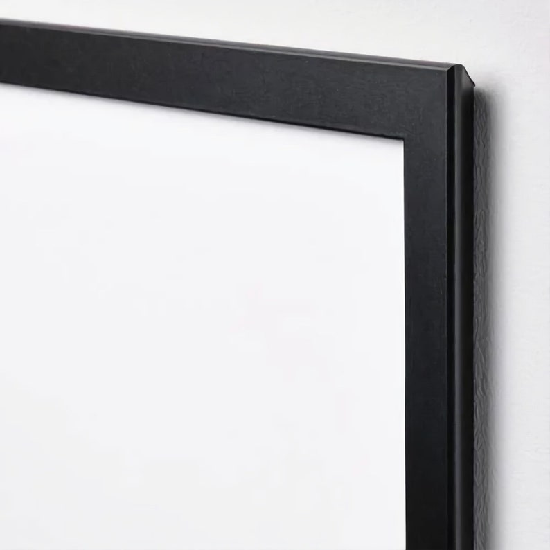 May include: A black picture frame with a white mat. The frame is made of wood and has a simple, modern design.