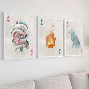 K&ouml;nnte beinhalten: Drei gerahmte Drucke von Spielkarten mit Illustrationen von Figuren aus dem Film Chihiros Reise ins Zauberland. Das Ass Herz zeigt einen wei&szlig;en und rosa Drachen, der K&ouml;nig Kreuz zeigt einen Feuergeist und die Dame Karo zeigt einen wei&szlig;en Wolf.