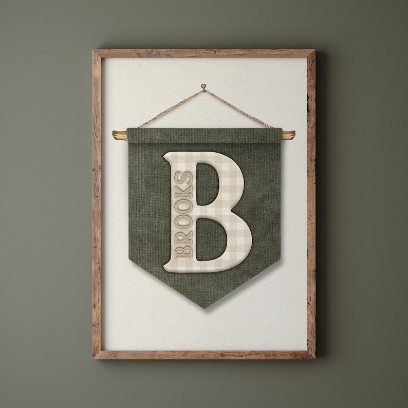 May include: A framed wall banner with a green background and a large, off-white letter "B" in the center. The letter has a plaid pattern. The word "BROOKS" is printed vertically on the left side of the banner. The banner is suspended by a rope.