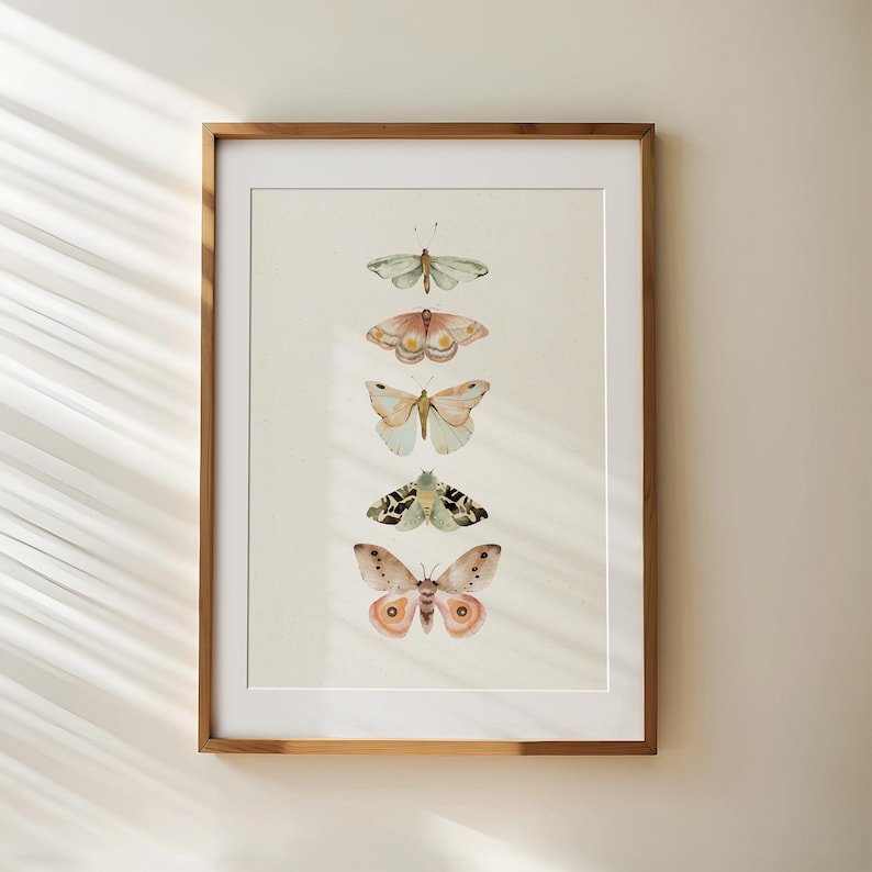 May include: A framed print featuring a vertical arrangement of five watercolor butterflies in shades of pink, green, and brown. The butterflies are arranged in a row, with the largest butterfly at the bottom and the smallest butterfly at the top.