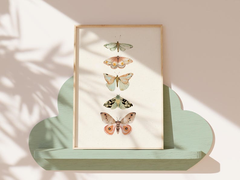 May include: A framed print with a white background featuring five different butterflies in a vertical row. The butterflies are painted in shades of green, brown, and orange.