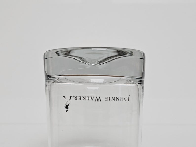 Peut inclure: Verre &agrave; boire transparent avec un dessus l&eacute;g&egrave;rement incurv&eacute;. Les mots "JOHNNIE WALKER" sont imprim&eacute;s en noir, accompagn&eacute;s d'un petit logo. Le verre est clair et est con&ccedil;u pour servir des boissons.