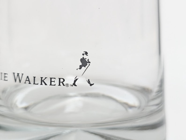 Peut inclure: Verre transparent avec l'inscription "IE WALKER" et une silhouette noire d'un homme marchant avec une canne. Le verre a une base arrondie et une surface lisse et transparente.