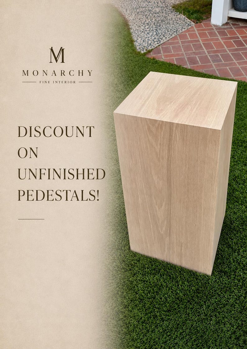May include: A light-coloured, unfinished wooden pedestal with a rectangular shape. The pedestal is displayed on green grass. Text on the left side reads "Discount on Unfinished Pedestals!" and the Monarchy Fine Interior logo.