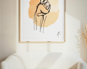 Könnte beinhalten: Ein gerahmter Kunstdruck mit einer schwarzen Strichzeichnung von zwei sich umarmenden Figuren. Die Figuren sind über einem weichen, kreisförmigen, hellorangen Aquarellfleck zentriert. Unten rechts befindet sich eine kleine, stilisierte Signatur.