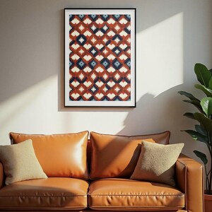Könnte beinhalten: Ein gerahmter, rechteckiger Wandkunstdruck mit einem sich wiederholenden geometrischen Muster aus weißen, dunkelblauen und rostfarbenen Rautenformen. Das Kunstwerk befindet sich in einem dünnen schwarzen Rahmen und zeigt ein symmetrisches Design.
