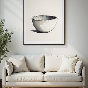 Könnte beinhalten: Ein gerahmter Wandkunstdruck mit einer zentrierten Illustration einer einzelnen, abgerundeten Keramikschale. Die Schale ist in Weiß-, Grau- und Schwarztönen gehalten und zeigt ein schlichtes, klares Design mit einem sichtbaren Schatten darunter.