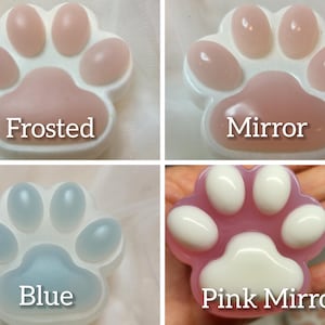 Puede incluir: Cuatro moldes de jabón con forma de pata. El primer molde es blanco esmerilado con la palabra "Frosted" escrita en él. El segundo molde es blanco con un acabado de espejo y la palabra "Mirror" escrita en él. El tercer molde es azul con la palabra "Blue" escrita en él. El cuarto molde es rosa con un acabado de espejo y la palabra "Pink Mirror" escrita en él.