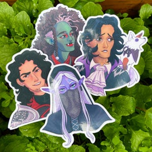 May include: A selection of five fantasy character stickers. The stickers depict illustrations of diverse characters, including a green-skinned figure, a character with long white hair, and a character with a small white dog.