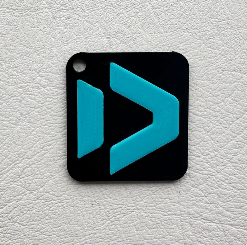 Peut inclure: Un porte-cl&eacute;s carr&eacute; noir avec une fl&egrave;che turquoise pointant vers la droite.