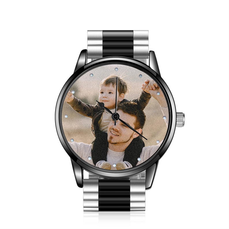 May include: A wristwatch featuring a custom photo dial showing a person carrying a child on their shoulders. The watch has a round black case, a black and silver metal link band, and simple hour markers around the edge of the watch face.