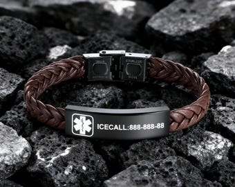 Puede incluir: Una pulsera de cuero trenzado marrón con un cierre de acero inoxidable negro. La pulsera presenta una placa de identificación negra con el texto "ICECALL:888-888-88" y un símbolo médico.