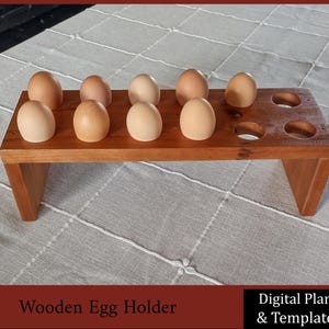 May include: A wooden egg holder with 10 slots for storing eggs. The holder is made of natural wood and has a rustic look. It is sitting on a white tablecloth.