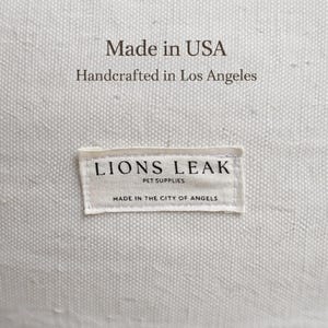 Lions Leak dog bed label close up, made in USA handcrafted pet bed, natural cotton canvas fabric detail, premium handmade dog bed branding tag