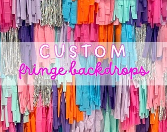 May include: A colorful fringe backdrop with the text "CUSTOM fringe backdrops" in pink lettering.