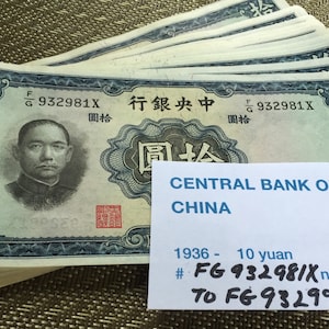 May include: A stack of 17 vintage Chinese bank notes from 1936, each featuring a portrait of a man in a suit and the text "Central Bank of China" in English and Chinese. The notes are in good condition and have a blue and white color scheme.