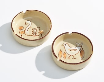 Een paar vintage keramische asbakken uit het midden van de 20e eeuw met vogel- en zwaanmotieven.