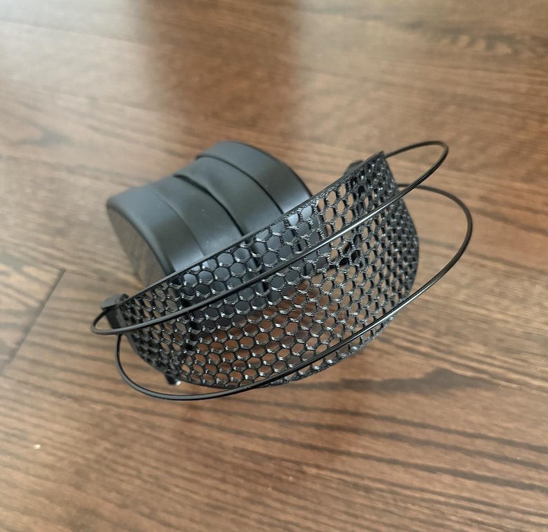 Puede incluir: Auriculares negros con diadema de malla. La diadema est&aacute; hecha de malla met&aacute;lica negra con un patr&oacute;n de panal.