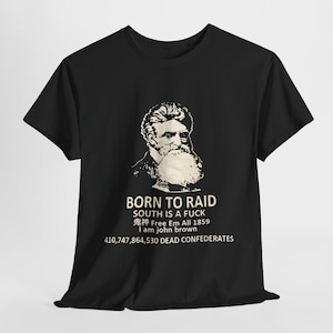 May include: Black t-shirt featuring a white graphic of a bearded man and text that reads "BORN TO RAID SOUTH IS A FUCK Free Em All 1859 I am john brown 410,747,864,530 DEAD CONFEDERATES."