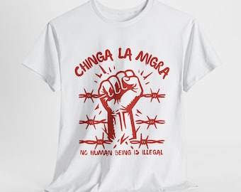 May include: White t-shirt with a red graphic. The graphic features a clenched fist within barbed wire, with the words "CHINGA LA MIGRA" above and "NO HUMAN BEING IS ILLEGAL" below. The design is centered on the shirt.