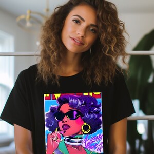 May include: Black t-shirt with a colorful graphic print of a woman wearing sunglasses and a gold hoop earring. The graphic has the text "I Was Born To Shine" in pink and purple.