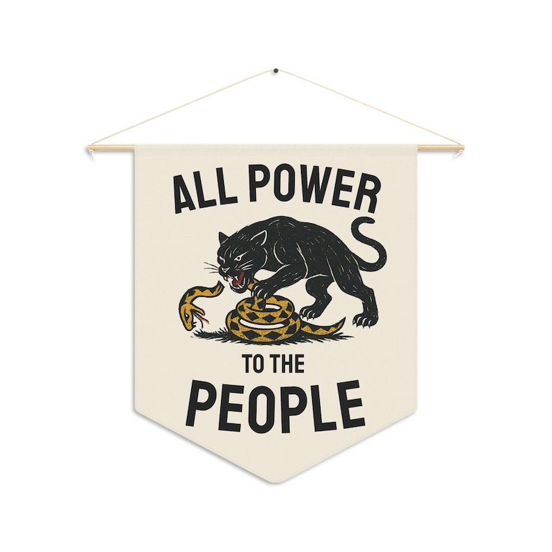 Cream-colored wall banner with the words "ALL POWER TO THE PEOPLE" in bold black letters. A black panther is depicted attacking a yellow and brown snake. The banner is suspended from a wooden rod.