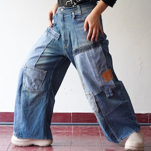 Könnte beinhalten: Weitbeinige Jeans aus Patchwork-Denimstoff. Die Jeans sind blau und haben mehrere Taschen und Nähte.