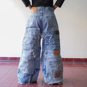 May include: Light blue denim jeans, constructed from multiple pairs of jeans, featuring various pockets and distressed details. The jeans have a wide-leg design and multiple Levi's brand tags.