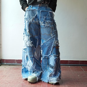 May include: Wide-leg denim jeans with a patchwork design. The jeans are constructed from various shades of blue denim, with visible seams and frayed edges. The jeans have multiple pockets and a high waist.