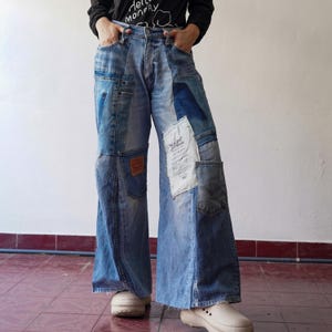 Puede incluir: Vaqueros de pierna ancha de mezclilla con detalles de patchwork en varios tonos de azul. Los vaqueros tienen varios bolsillos y están hechos de una combinación de telas de mezclilla.