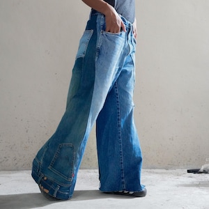 Peut inclure: Jean à jambes larges composé de multiples panneaux de denim dans des nuances de bleu variées. Le vêtement présente une coupe taille haute avec des poches visibles, une petite étiquette rouge sur le côté et un bord inférieur brut non ourlé.