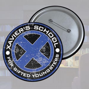 Può includere: Un bottone blu e nero con il testo "Xavier's School for Gifted Youngsters" e una X blu al centro. Il bottone è di stile circolare con chiusura a spilla.