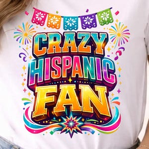 May include: White t-shirt with the text "CRAZY HISPANIC FAN" in vibrant, colorful lettering. The design includes fireworks, decorative banners, and a starburst, creating a festive and eye-catching graphic. The shirt is a casual wear item.
