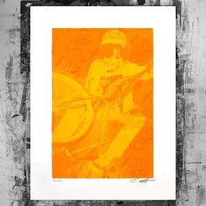 Peut inclure: Impression artistique orange et jaune représentant un cycliste avec un casque et des lunettes. L'impression a un effet de demi-teinte et inclut le nom "RUPE". Le cycliste est sur un vélo.