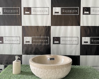 May include: A beige stone washbasin with a textured, basket-weave-like exterior. A matching soap dispenser stands to the left. The background features a black and white checkered pattern with the text "THE WASHBASIN STUDIO".